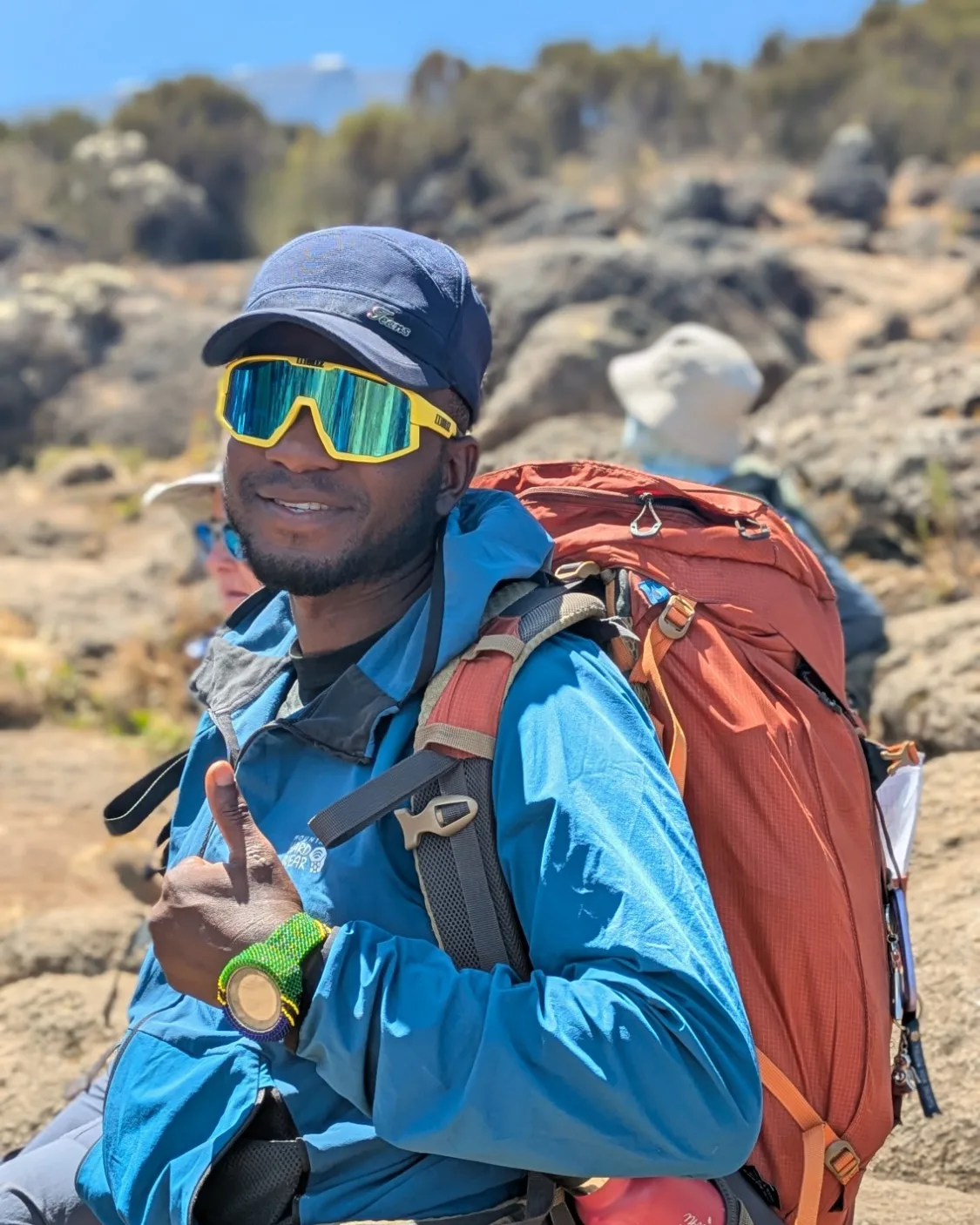 Fedrick Choda resting on the trail with his pack