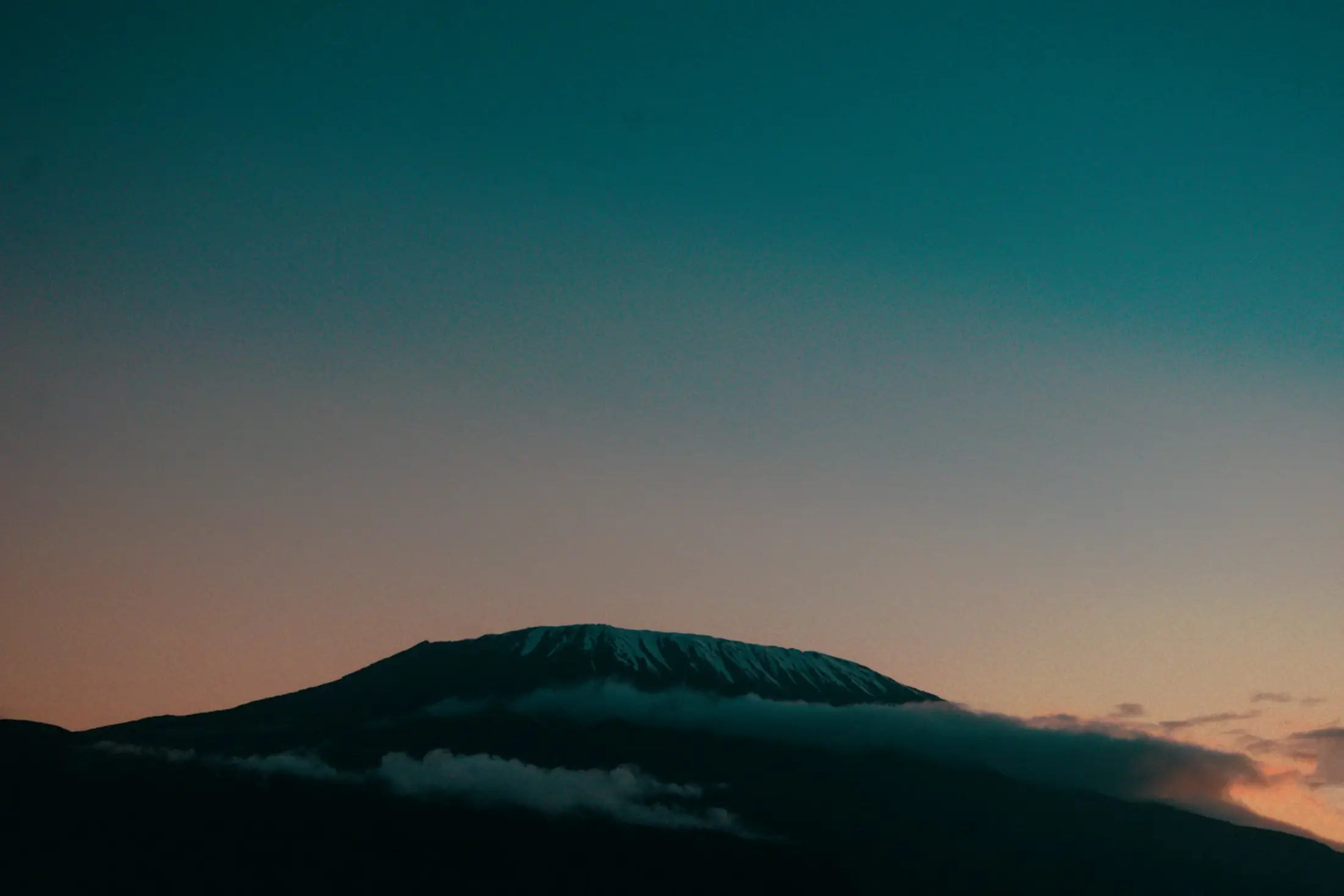 Mount Kilimanjaro silhouetted against a dusk sky