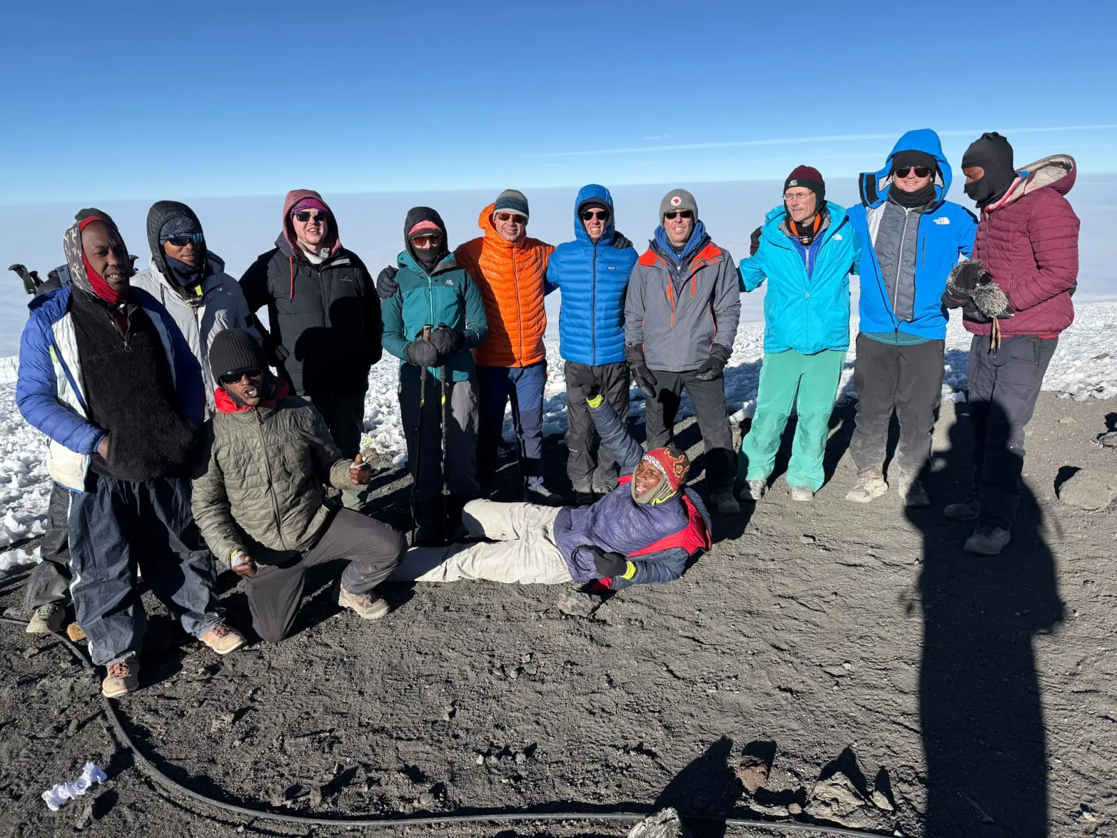 A large group of climbers and guides at the summit of Kilimanjaro on the crater rim