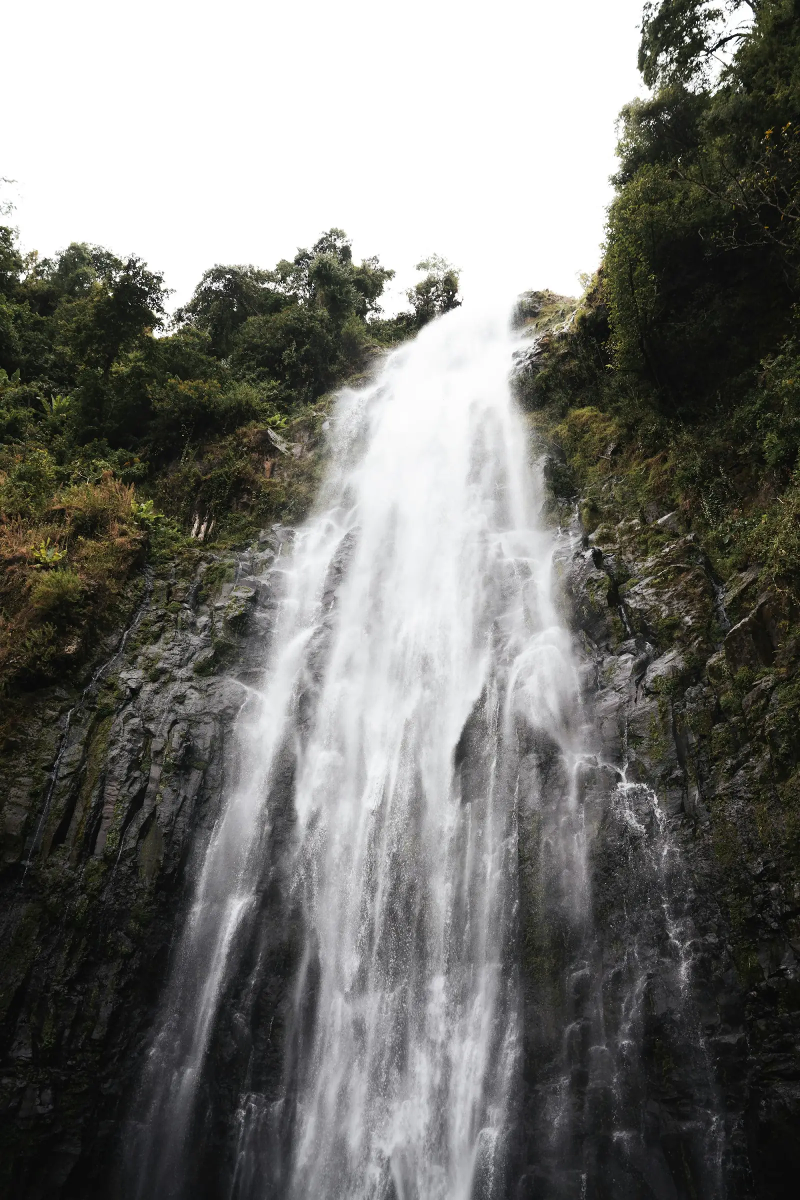 A tall waterfall falling down a rock face